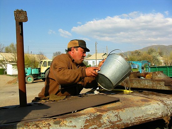 Foto van mijn schoonvader die het koelwater van de bulldozer bijvult