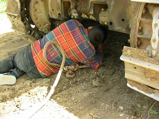 Foto van het bevestigen van de staalkabel onder de bulldozer