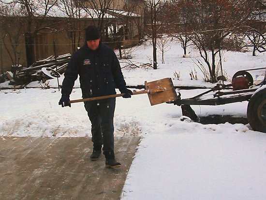 Sneeuwruimen van de betonnen oprit